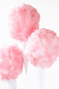 three pink cotton candy balls in a white vase