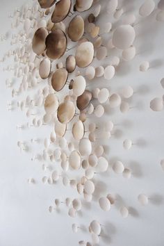 a white wall with lots of circles hanging from it's sides and on the side