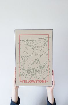 a person holding up a drawing with the words yellowstone on it in front of their face