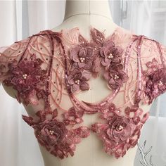 the back of a mannequin with pink flowers on it's neckline