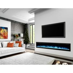 a living room with a white couch and large flat screen tv mounted on the wall