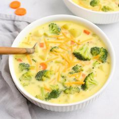 two bowls filled with broccoli cheese soup on top of a white tablecloth