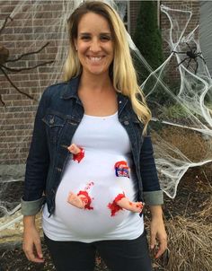 a pregnant woman with her handprints on her belly, smiling at the camera