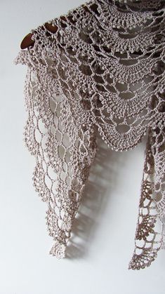 a close up of a crocheted shawl on a white background