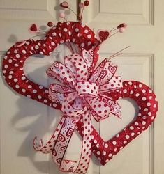 a red and white heart shaped door hanger with polka dot ribbon on it's side