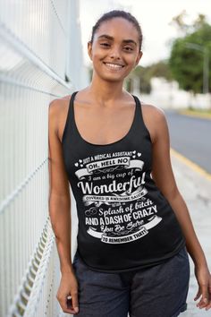 a woman standing next to a fence wearing a tank top that says wonderful and dash of crazy