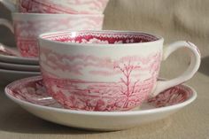 three cups and saucers sitting on top of each other in front of a beige background