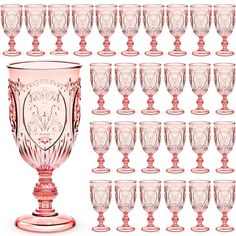 a large set of pink glass goblets sitting next to each other on a white background