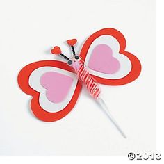 a red and white butterfly with pink hearts on it's wings sitting on top of a stick