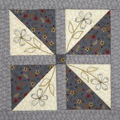 a quilted square with flowers and butterflies on the center is shown in grey fabric