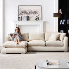 a woman sitting on top of a white couch