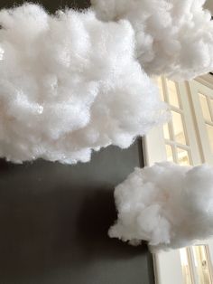 fluffy clouds are hanging from the ceiling in a room with black walls and white trim