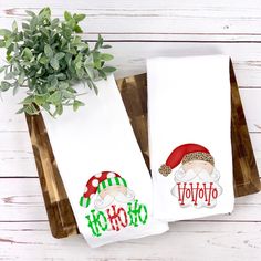 two white towels with santa hats and the words ho hoo on them sitting next to a potted plant