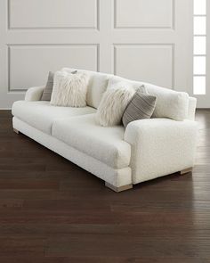 a white couch sitting on top of a hard wood floor