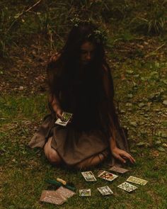 a woman sitting on the ground surrounded by cards