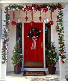 a red front door decorated with christmas decorations