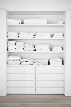 a white closet filled with lots of clothes