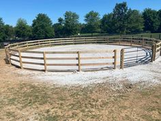 an empty horse pen in the middle of a field