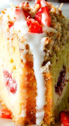 a close up of a piece of cake on a plate with strawberries and icing