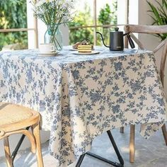 a table that has some flowers on it and a potted plant in the corner