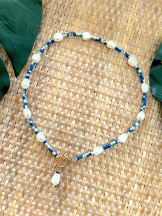 Welcome to our Coastal Inspired Beaded Pearl Necklace – a stunning blend of elegance and coastal charm, inspired by the breathtaking coastline of Santorini, Greece! 🌊✨Crafted with care and attention to detail, this necklace features a beautiful combination of unique tie-dyed bright blue and white coconut shell heishi beads, reminiscent of the colors of the Aegean Sea, and lustrous 9mm freshwater pearls. Each bead is carefully selected to evoke the serene beauty of Santorini's coastline, creatin Artisan Blue Jewelry For Beach, Artisan Blue Jewelry For The Beach, Ocean-inspired Blue Strand Jewelry, Blue Ocean-inspired Jewelry For Vacation, Elegant Handmade Blue Shell Necklace, Blue Ocean-inspired Strand Jewelry, Blue Strand Necklace With Ocean-inspired Style, Bohemian Blue Strand Jewelry, Blue Bohemian Strand Jewelry