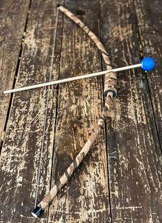 a bow and arrow laying on top of a wooden table next to a blue ball