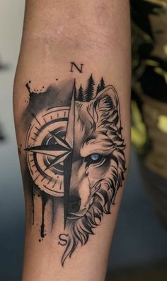 a man's arm with a compass tattoo on it and a lion head in the middle