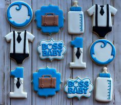 baby shower cookies decorated with blue and white icing on a wooden surface, including an infant's first year