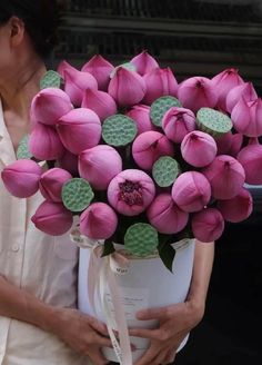 a woman holding a bouquet of pink flowers