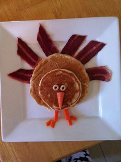 a white plate topped with a turkey shaped pancake