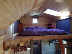 a bed sitting in the middle of a room under a roof