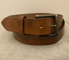 Vintage SAKS FIFTH AVENUE Men's casual brown burnished leather belt with removable solid cast buckle and prong.   Markings: 38/95 Made in Canada, South American Leather,  FH086IB This belt is from the SFA men's collection but is certainly appropriate for women.  This belt is not contoured.  Overall length end to end including buckle: 47" Fastens between: 36"-40" Width: 1.5" Excellent vintage condition.  No damage.  This belt has been worn and loved, and has developed a rich and authentic patina, with visible areas of darkening, and light abrasion.  No rips, no tears.  The two snaps hold the buckle securely. Box 1 Adjustable Brown Belt Buckles For Business, Brown Belt With Buckle For Everyday Use, Brown Belts And Suspenders With Antique Buckle For Business, Rugged Distressed Brown Belt Buckle With Antique Buckle, Classic Brown Belt With Antique Buckle, Rugged Distressed Brown Belt Buckle With Antique Finish, Distressed Brown Rugged Belt Buckle With Antique Finish, Rugged Brown Belt Buckles With Antique Buckle, Adjustable Brown Bridle Leather Belt Buckles