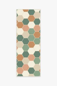 an orange, green and white rug with hexagonal shapes on it's sides