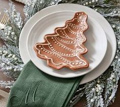 a plate with a cookie shaped like a christmas tree on it next to a green napkin