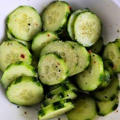 a white bowl filled with sliced cucumbers