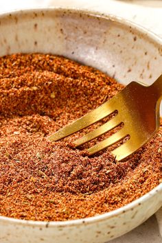 a fork in a bowl filled with spices