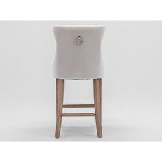 an upholstered bar stool with a button on the back and wooden legs, against a white background