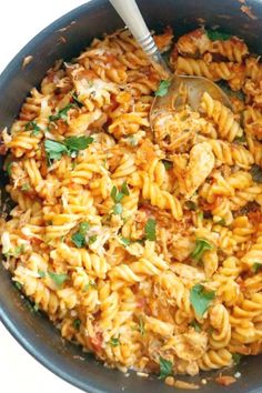 a skillet filled with pasta and meat