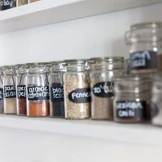 the shelves are filled with different types of spices and seasonings in glass jars on white shelving