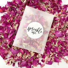 a bag filled with pink flowers sitting on top of a pile of dried flower petals