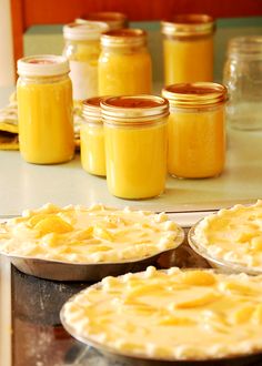 several pies sitting on top of a table covered in yellow liquid and cheese sauce