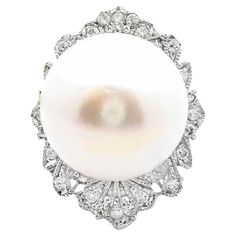 A striking and elegant cocktail ring featuring a lustrous 14.0 mm white pearl. The pearl is encircled by 0.42 carats of round, brilliant-cut white diamonds, adding a touch of sparkle and sophistication. Crafted in 18k white gold, this contemporary piece is a testament to modern design. This ring is both sizable and ready to be worn. Ring Size: 5.75 Weight: 9.7 grams Sea Pearl, 18k Gold Ring, South Sea Pearls, Sea Pearls, Pearl Diamond, The Pearl, White Diamonds, Cocktail Ring, White Pearl