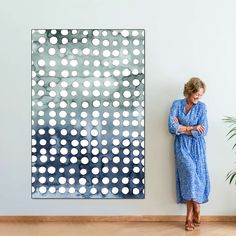 a woman standing in front of a painting on the wall