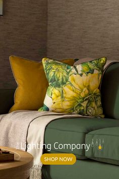 a green couch with yellow flowers on it and the words lighting company shop now above it