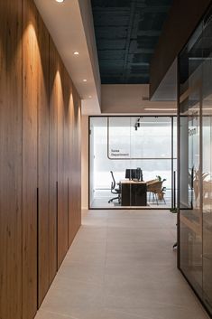 an office with wood paneling and glass walls