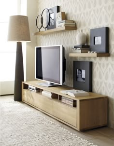 a living room with two televisions and bookshelves on the wall next to each other