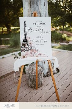 an easel with a sign that says welcome to the bride and groom in front of the eiffel tower