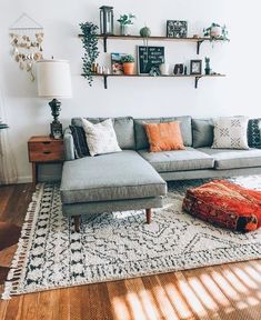 a living room filled with furniture and lots of pillows on top of a wooden floor