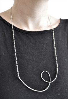 This elegant handmade necklace is solid sterling silver with a unique design. The long chain of 56cm simply slips over the head. The silver swirl is 10.5cm wide making this a bold but simple statement piece suitable for all occasions.  - Weight: 12.5g - Comes packaged with branded carboard packaging and organza giftbag. - Giftbox option available for additional cost. Modern Twist Sterling Silver Necklace In Silver, Modern Twist Sterling Silver Necklace, Modern Twist Silver Sterling Silver Necklace, Modern Silver Spiral Necklace, Minimalist Silver Spiral Necklace, Loop Necklace, Wedding Jewellery Necklace, Long Chain, Handmade Necklace