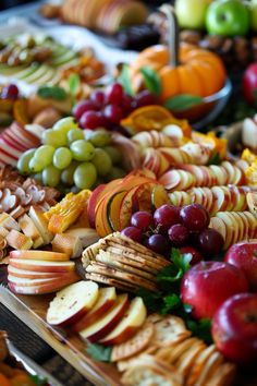 an assortment of fruits and cheeses are arranged on trays for serving to the guests